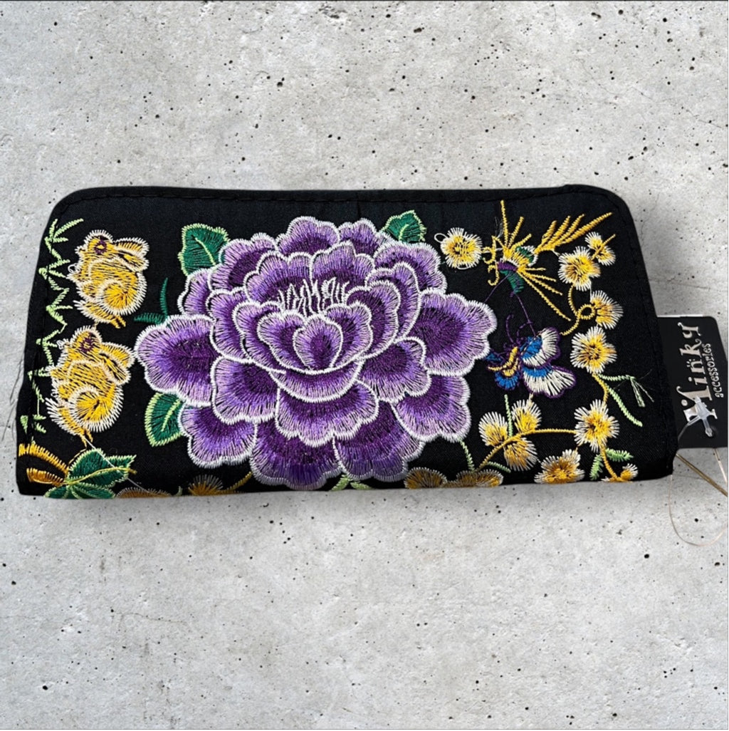 Black Fabric 8x4” zip around wallet with a vibrant purple embroidered flower and yellow embroidered flowers