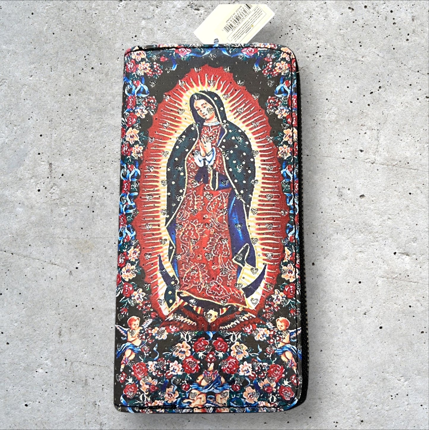 8x4 zip around faux leather wallet of Virgen de Guadalupe surrounded by flowers and cherubs and imbedded heart shaped rhinestones