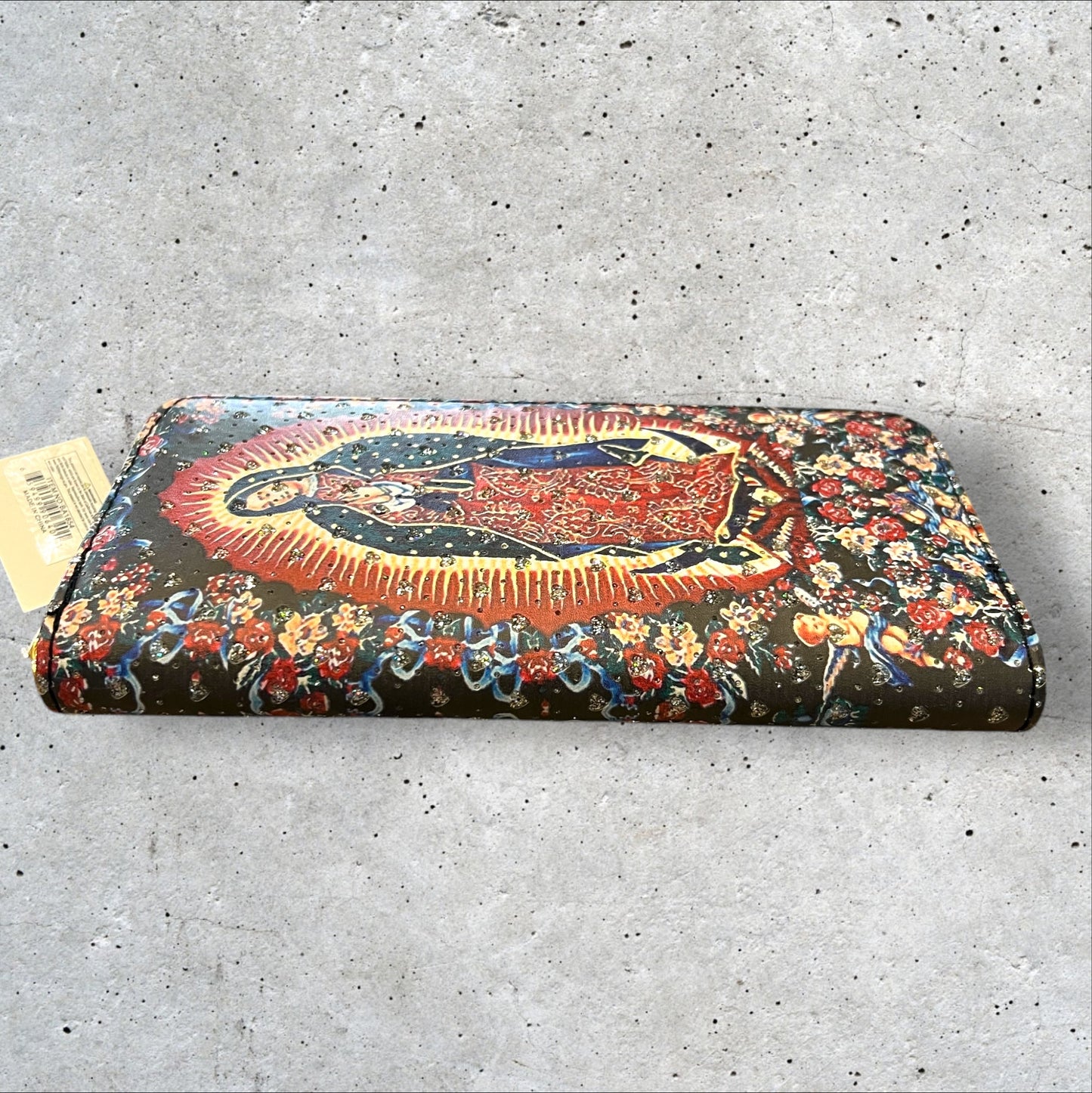 8x4 zip around faux leather wallet of Virgen de Guadalupe surrounded by flowers and cherubs and imbedded heart shaped rhinestones