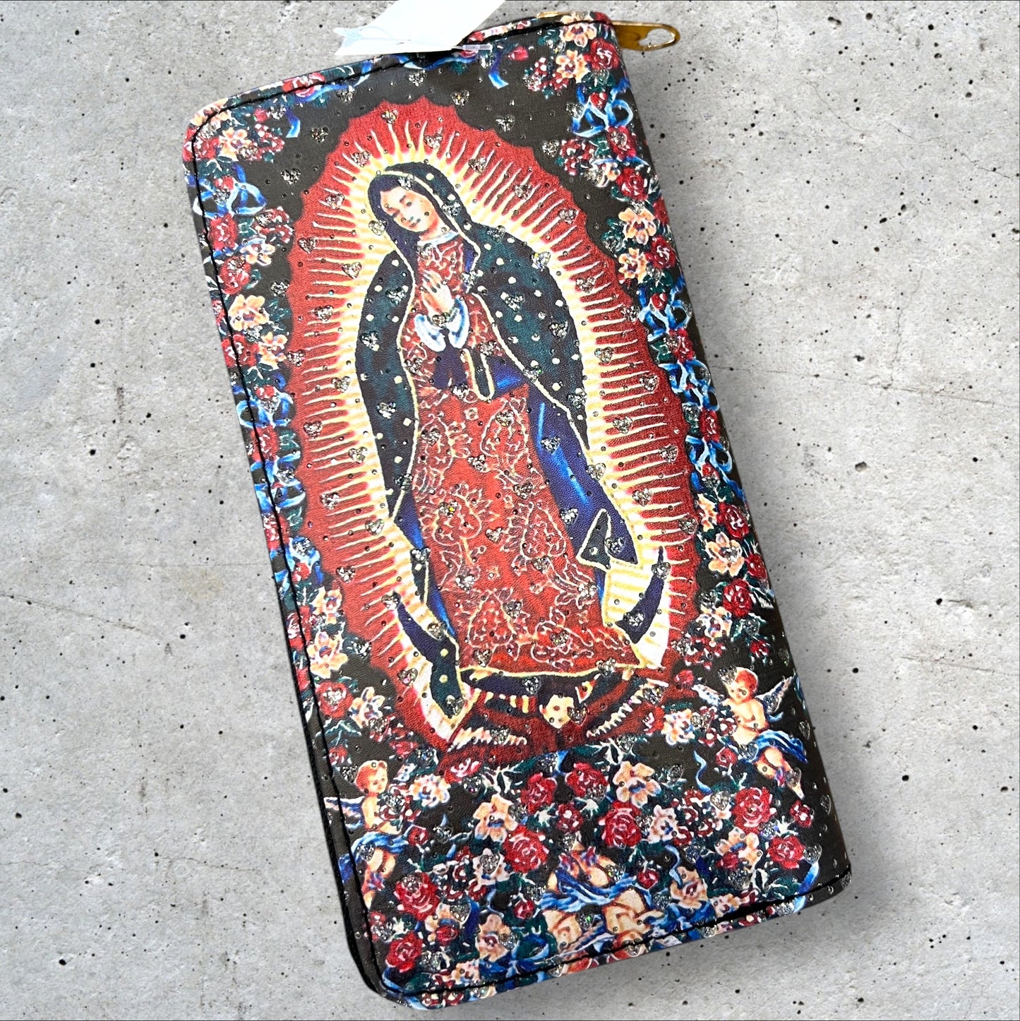 8x4 zip around faux leather wallet of Virgen de Guadalupe surrounded by flowers and cherubs and imbedded heart shaped rhinestones