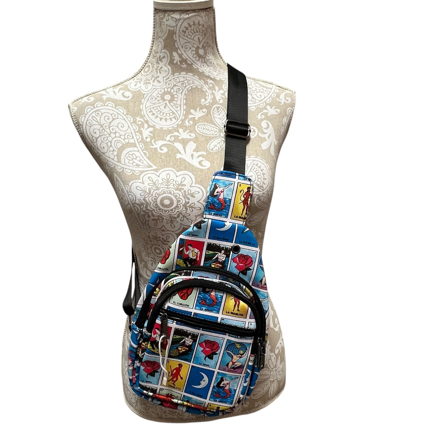 Mexican Loteria sling bag in vibrant colors featuring all of the game cards and has I main zippered compartment and black strap