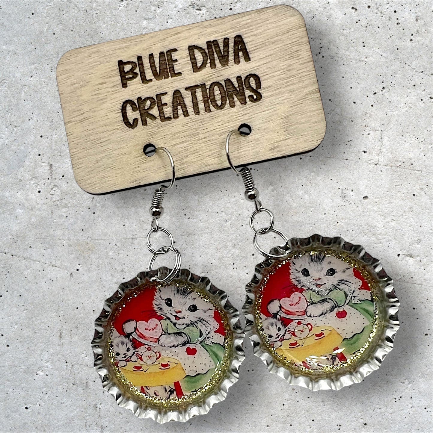 Valentine’s Day 1” bottle cap earrings featuring an image of a sweet white vintage retro cat accented with gold glitter and sealed in resin 