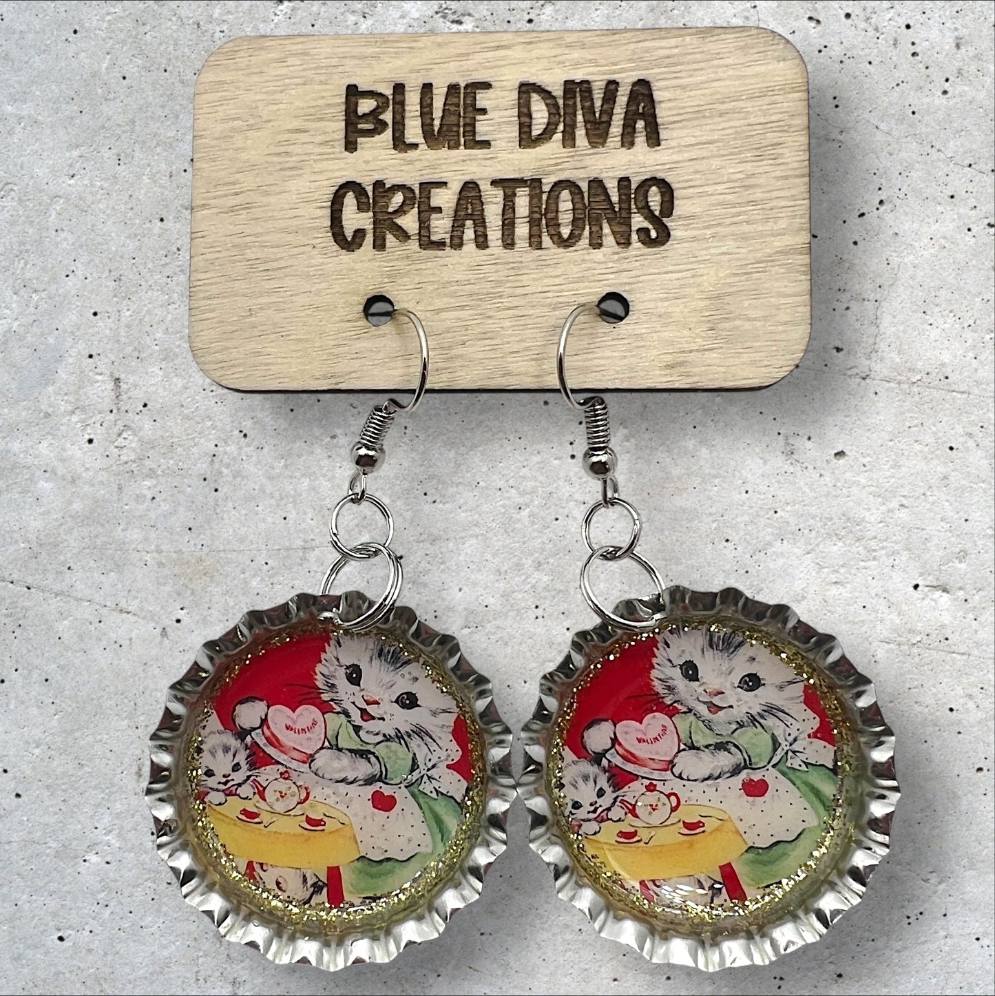 Valentine’s Day 1” bottle cap earrings featuring an image of a sweet white vintage retro cat accented with gold glitter and sealed in resin 